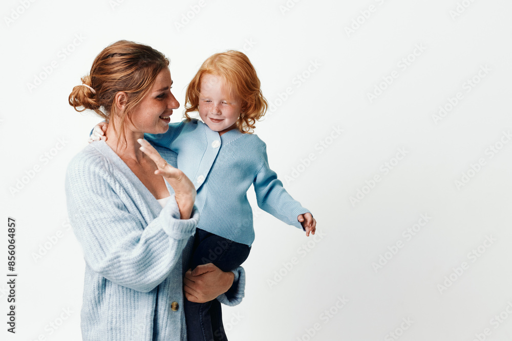 Mother and child smiling in front of white background, happiness and family concept, love and careful parenting portrait Mother and child smiling in front of white background, happiness and family concept, love and careful parenting portrait