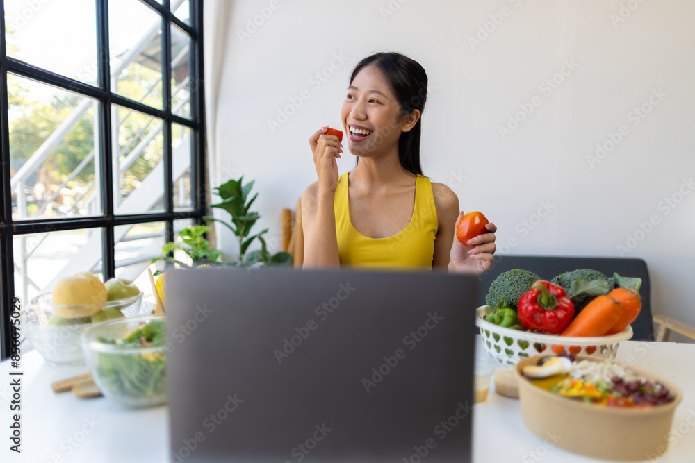 Beautiful Asian influencer woman making vegetable salad at home. Fitness influencer on social media online showing tomato for healthy eating. Vlogging and blogging online, weight loss and dieting. Beautiful Asian influencer woman making vegetable salad at home. Fitness influencer on social media online showing tomato for healthy eating. Vlogging and blogging online, weight loss and dieting.