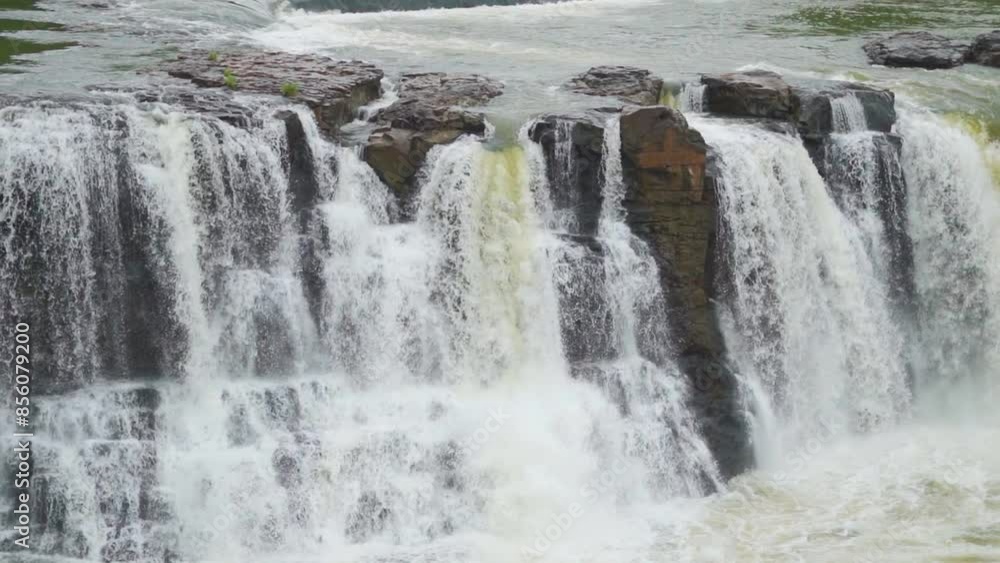 Slow mo shot of Gira waterfall flowing in full force from above the cliff at Waghai on the way to Saputara hill station in Gujarat, India. Waterfall of Sahyadri's during the monsoon season in India. Slow mo shot of Gira waterfall flowing in full force from above the cliff at Waghai on the way to Saputara hill station in Gujarat, India. Waterfall of Sahyadri's during the monsoon season in India.