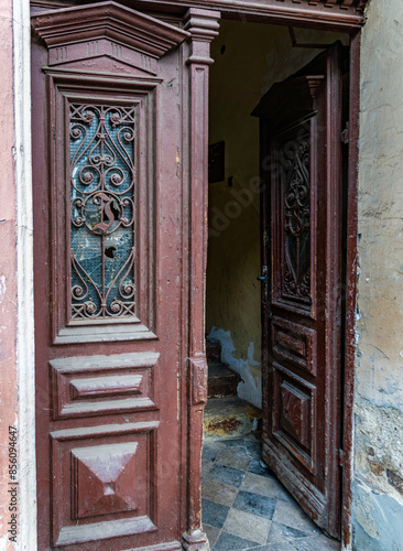 Old Wooden Door Ajar In Building Entrance photo