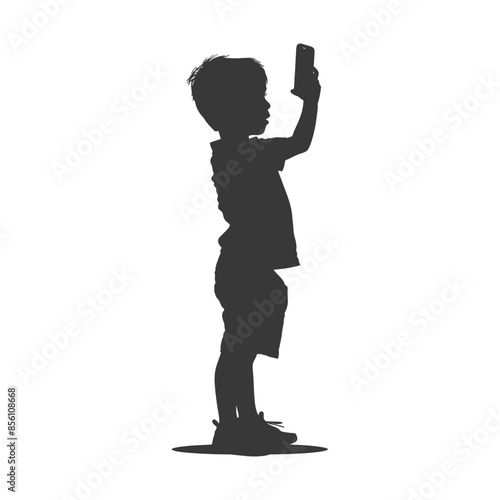 Silhouette of a young boy absorbed in a mobile phone screen.