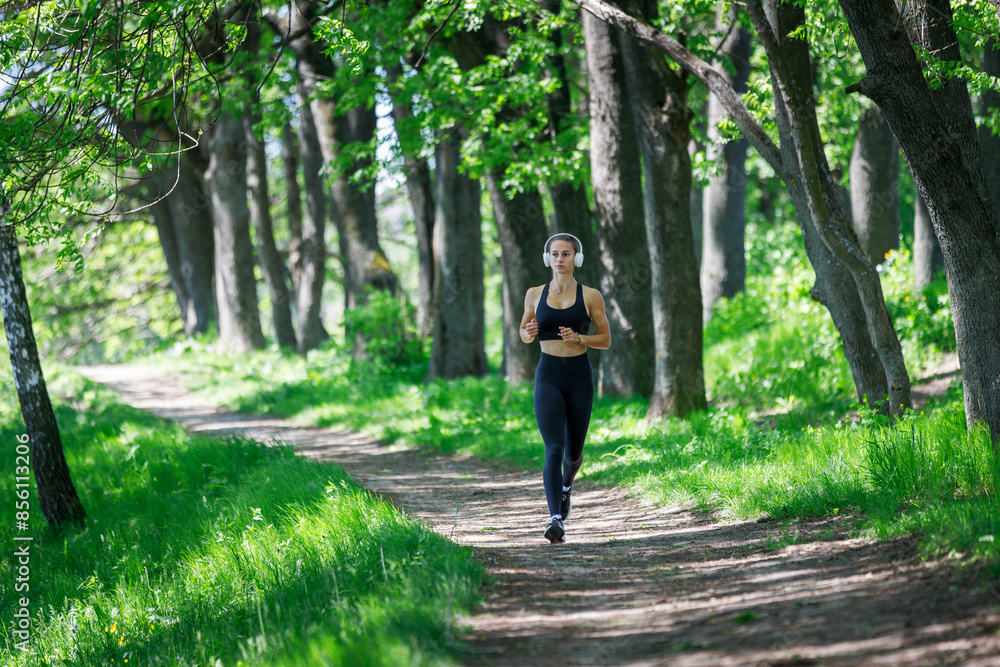 Young fitness woman jogging in park at sunny morning Young fitness woman jogging in park at sunny morning