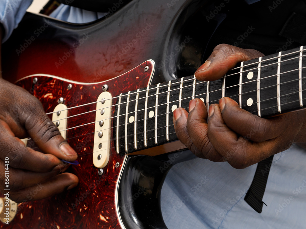 Naklejka premium hands of black man playing guitar detail close up