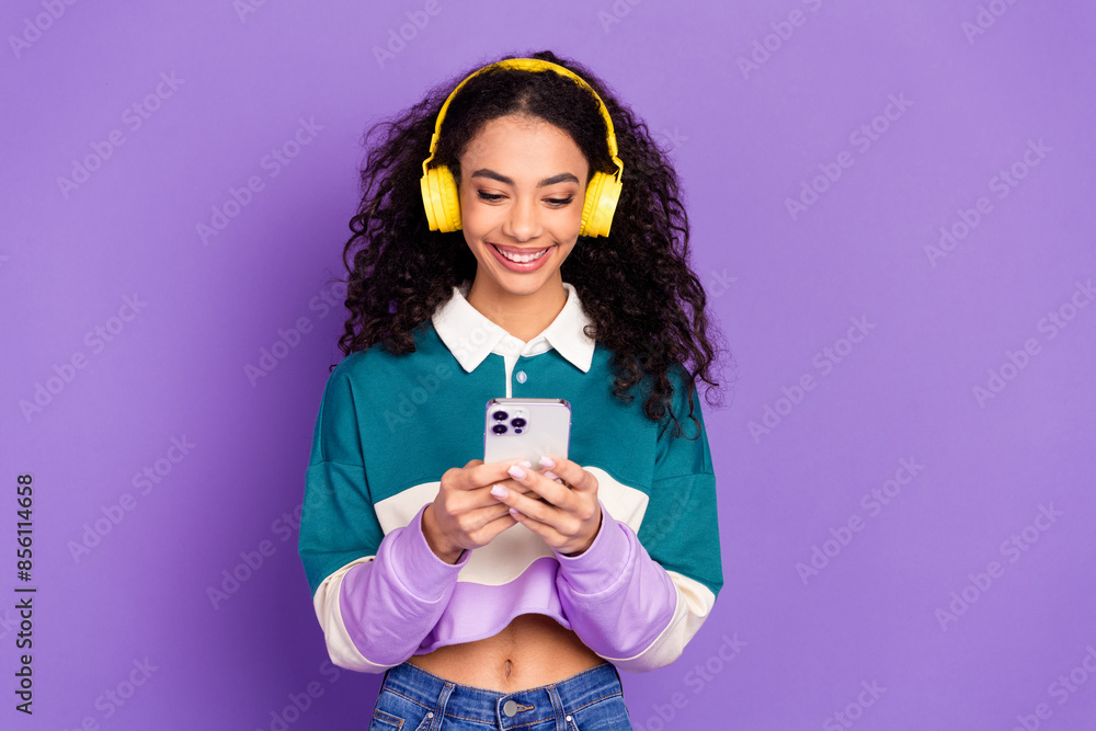 Portrait of lovely young girl smart phone headphones wear shirt isolated on purple color background Portrait of lovely young girl smart phone headphones wear shirt isolated on purple color background