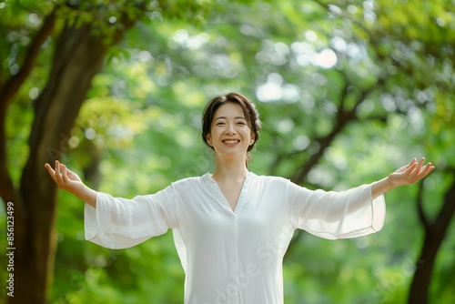 Happy Japanese woman enjoying nature with open arms, serene outdoor scene