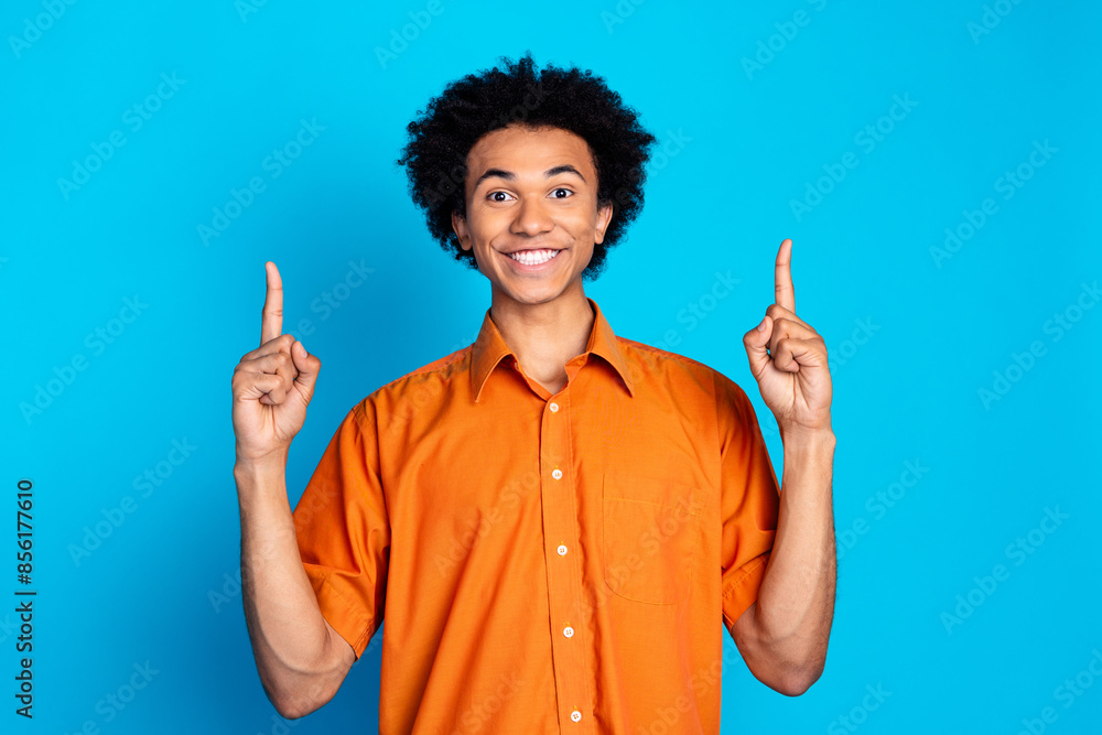 Photo of funky cool guy dressed orange shirt showing two fingers up emtpy space isolated blue color background Photo of funky cool guy dressed orange shirt showing two fingers up emtpy space isolated blue color background