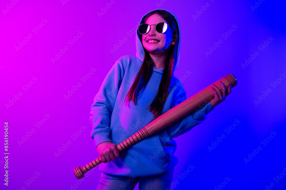 Obraz premium Photo of cool dreamy little lady dressed hoodie holding batter looking empty space isolated neon pink color background