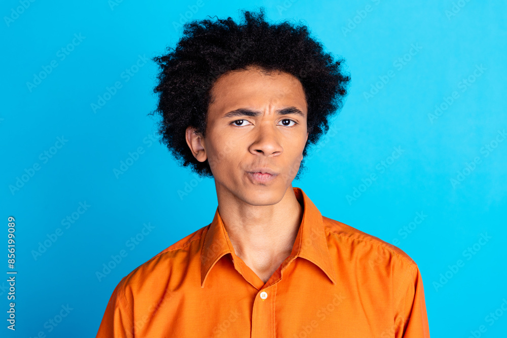 Photo of suspicios uncertain guy wear orange shirt looking you emtpy space isolated blue color background Photo of suspicios uncertain guy wear orange shirt looking you emtpy space isolated blue color background