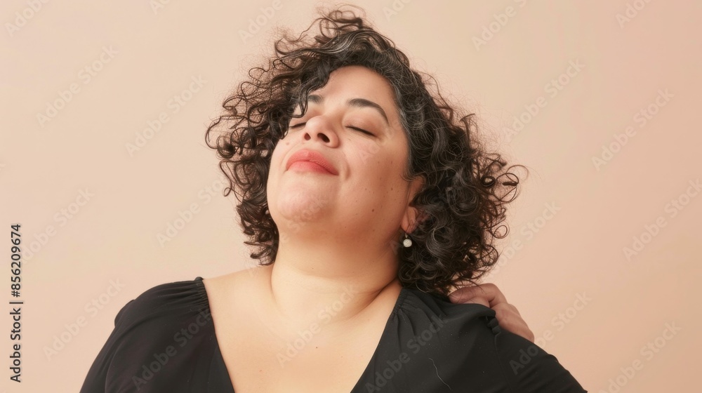 A woman with curly hair smiling gently with her eyes closed wearing a black top and having her head gently massaged. A woman with curly hair smiling gently with her eyes closed wearing a black top and having her head gently massaged.