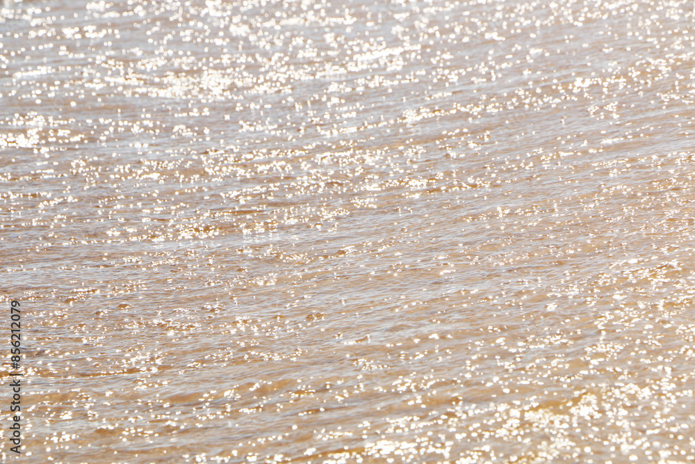 Obraz premium .Waves on the sunny sea coast. Magical reflections of the sun on the water, like a large number of lights. A beautiful holiday on the sea coast..