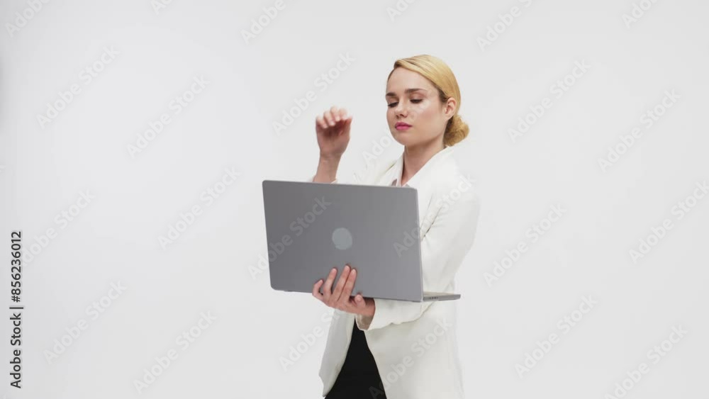 Business, confident blonde holds a laptop on a light background. After pressing the button, money appears from the laptop. Concept of payments, banking services and deposits. Business, confident blonde holds a laptop on a light background. After pressing the button, money appears from the laptop. Concept of payments, banking services and deposits.
