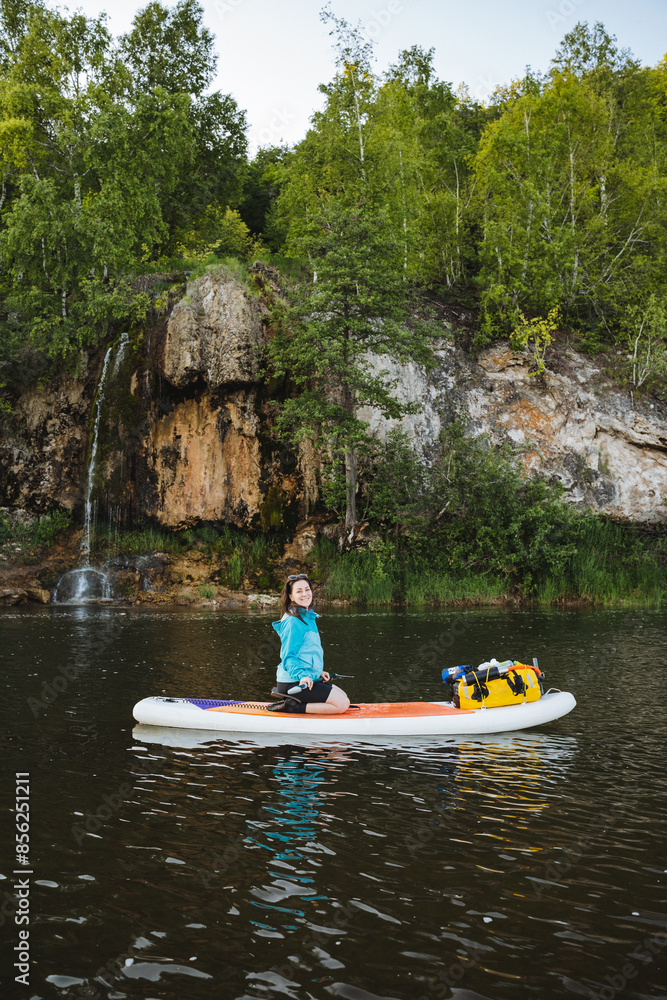 Observe the serene image of a woman peacefully paddleboarding on a tranquil mountain lake, surrounded by lush forests, finding solace in the calmness of nature Observe the serene image of a woman peacefully paddleboarding on a tranquil mountain lake, surrounded by lush forests, finding solace in the calmness of nature
