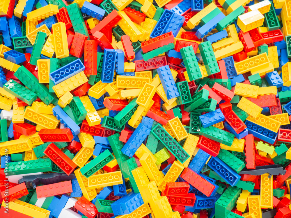 Multi-colored toy plastic blocks placed on green board. There are many blocks in the blurred background for children development and learning. Multi-colored toy plastic blocks placed on green board. There are many blocks in the blurred background for children development and learning.