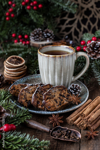 Mug with hot tea and Christmas cake with dried fruits and nuts