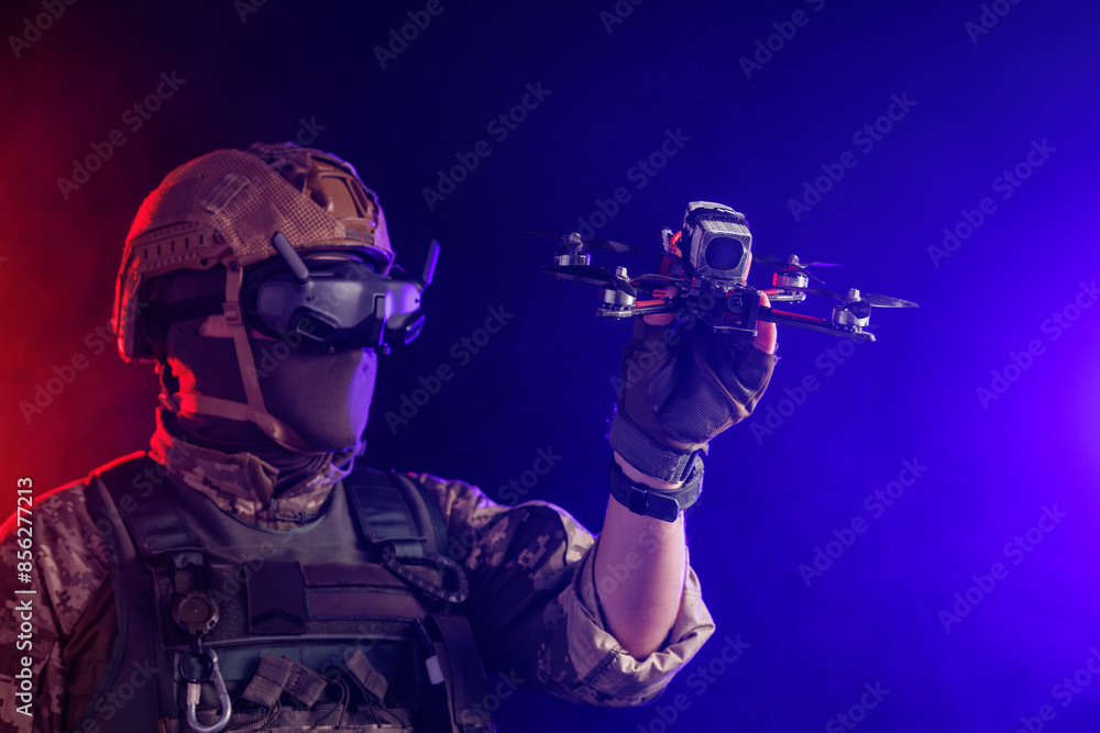 A soldier is depicted holding a drone while wearing stealth gear for military operations A soldier is depicted holding a drone while wearing stealth gear for military operations