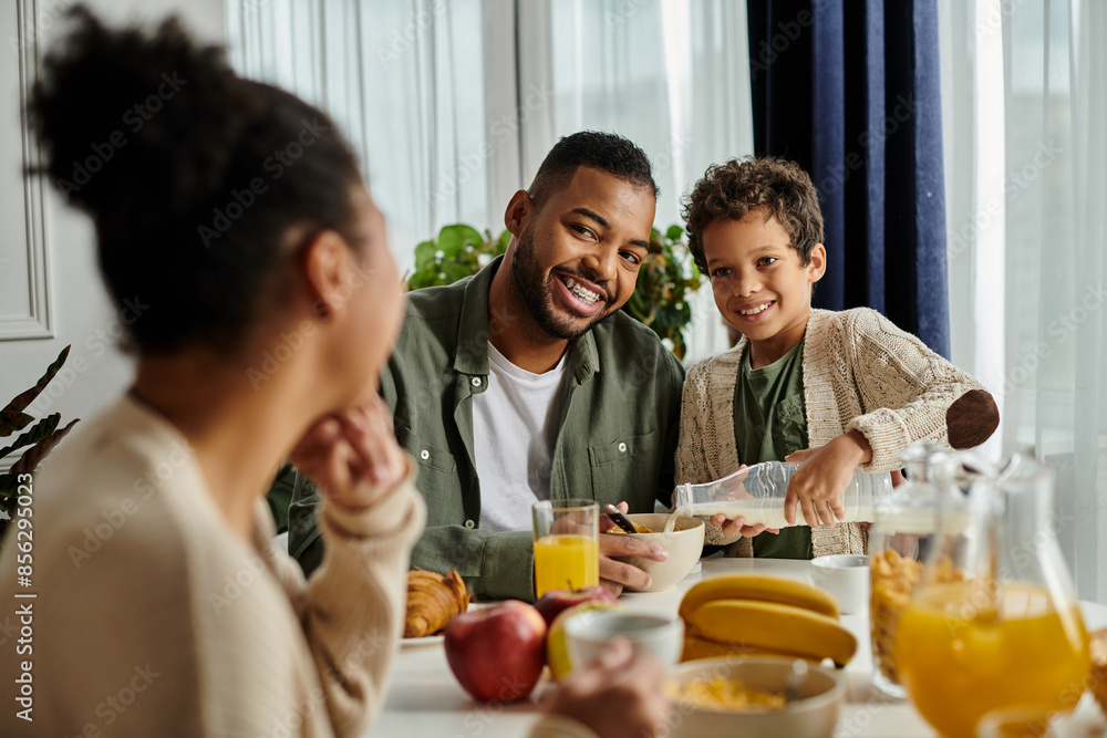 Close-knit African American family sharing food and conversation at the table. Close-knit African American family sharing food and conversation at the table.