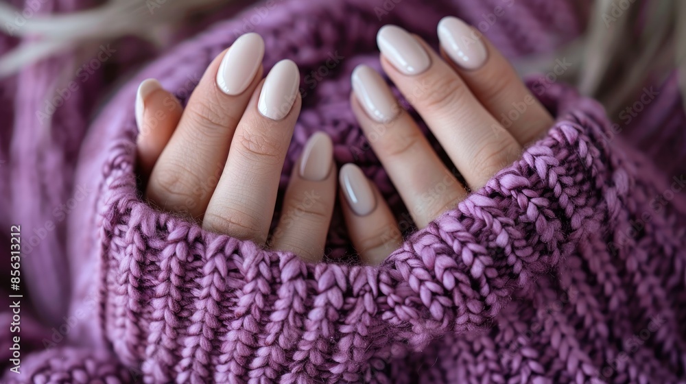 Stylish manicured hands of a woman in a purple sweater with winter beige gel nails Stylish manicured hands of a woman in a purple sweater with winter beige gel nails