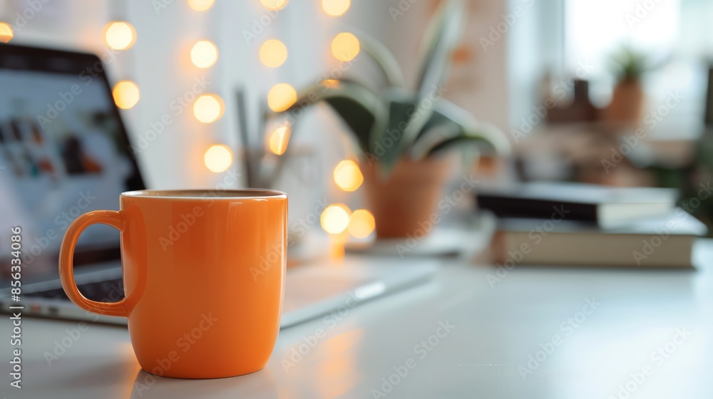 Cozy home office setup with an orange coffee mug, laptop, and plant, perfect for productive remote work or study sessions. Cozy home office setup with an orange coffee mug, laptop, and plant, perfect for productive remote work or study sessions.