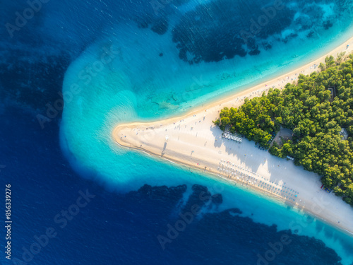 Fototapeta Naklejka Na Ścianę i Meble -  Aerial view of blue sea and Zlatni Rat, Brac island, Croatia in summer. Top drone view of adriatic sea, sandbank, white sandy beach, green trees, azure water at sunset. Tropical landscape. Travel