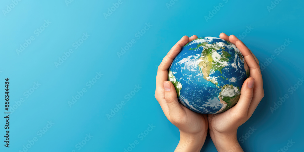 Person holding globe showing north and south america on blue background Person holding globe showing north and south america on blue background