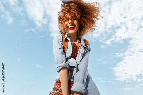 Fotografie Joyful woman dancing on the beach, embracing the freedom of the open sky: Beach-Traveling Happiness, Smiling Backpacker in Nature