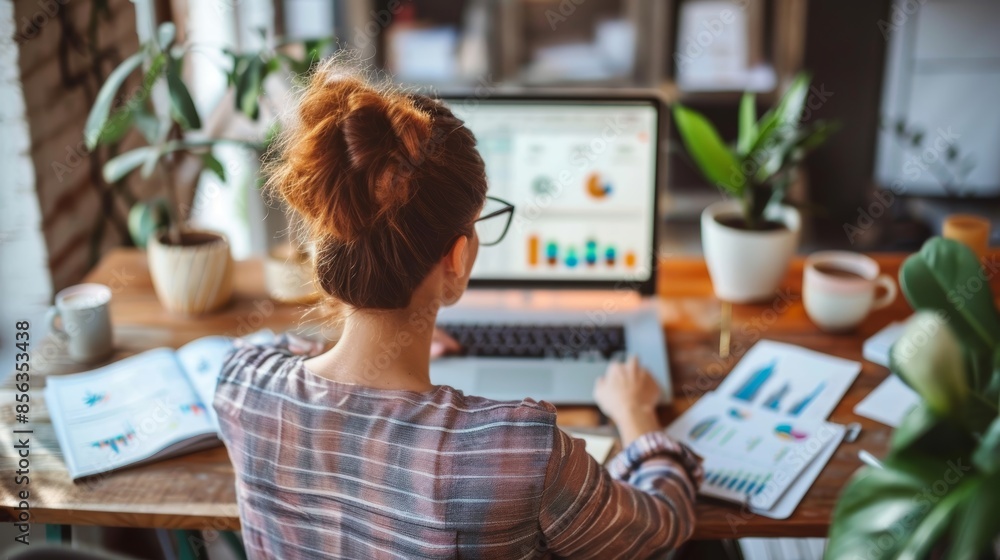 Successful Entrepreneur Analyzing Financial Charts in a Stylish Home Office Setting Successful Entrepreneur Analyzing Financial Charts in a Stylish Home Office Setting