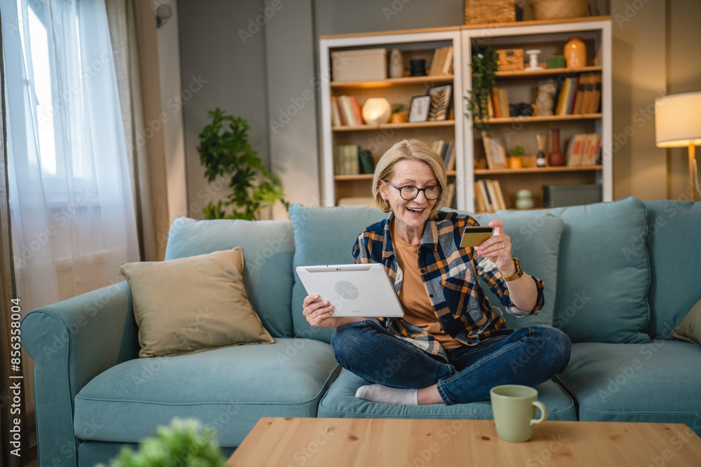 Senior woman caucasian female hold credit card online shopping at home Senior woman caucasian female hold credit card online shopping at home