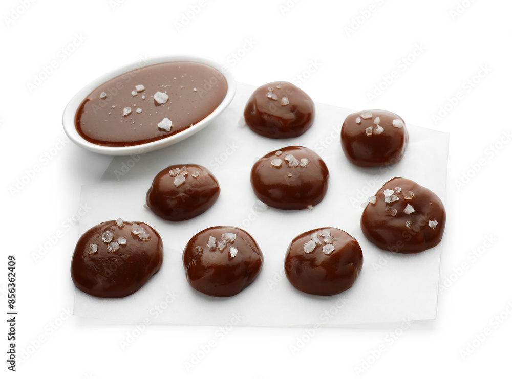 Tasty candies, caramel sauce and salt isolated on white Tasty candies, caramel sauce and salt isolated on white