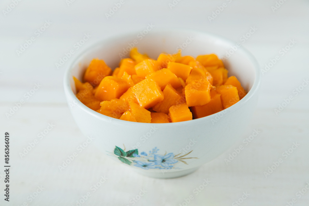 Ripe diced tropical mango fruit on ceramic on white ceramic bowl Ripe diced tropical mango fruit on ceramic on white ceramic bowl