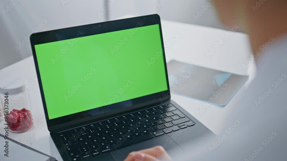 Doctor video calling green screen laptop in healthcare facility clinic closeup. Doctor video calling green screen laptop in healthcare facility clinic closeup.