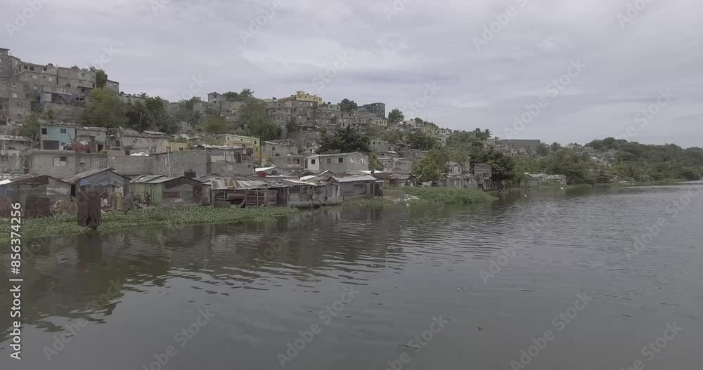 View of the Sea with Aquatic Plants Very Close to the Shore Next to Old and Poor Houses Built with the Remains of Construction Material due to the Losses Caused by the Hurricanes - Shot in Log View of the Sea with Aquatic Plants Very Close to the Shore Next to Old and Poor Houses Built with the Remains of Construction Material due to the Losses Caused by the Hurricanes - Shot in Log
