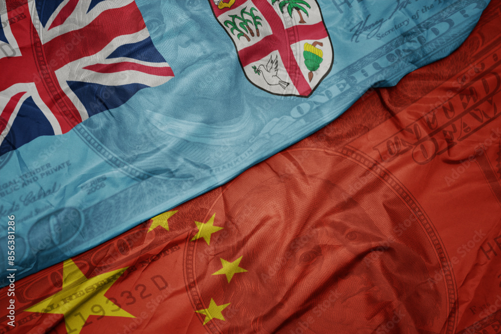 waving colorful flag of Fiji and national flag of china on the dollar money background. finance concept. waving colorful flag of Fiji and national flag of china on the dollar money background. finance concept.