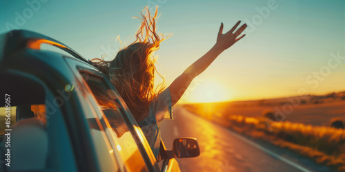 Fototapeta Naklejka Na Ścianę i Meble -  Carefree woman enjoying sunset road trip