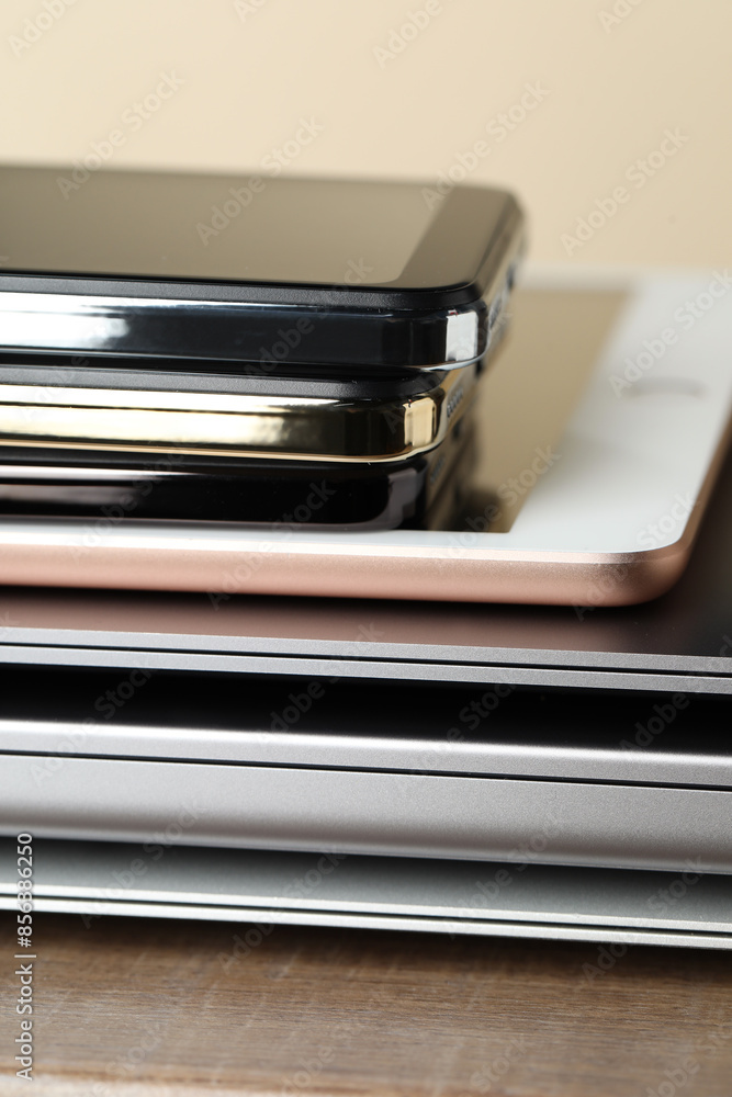 Stack of electronic devices on wooden table, closeup Stack of electronic devices on wooden table, closeup