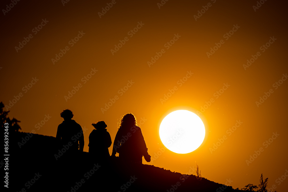 Fototapeta premium Family walking into orange sunset