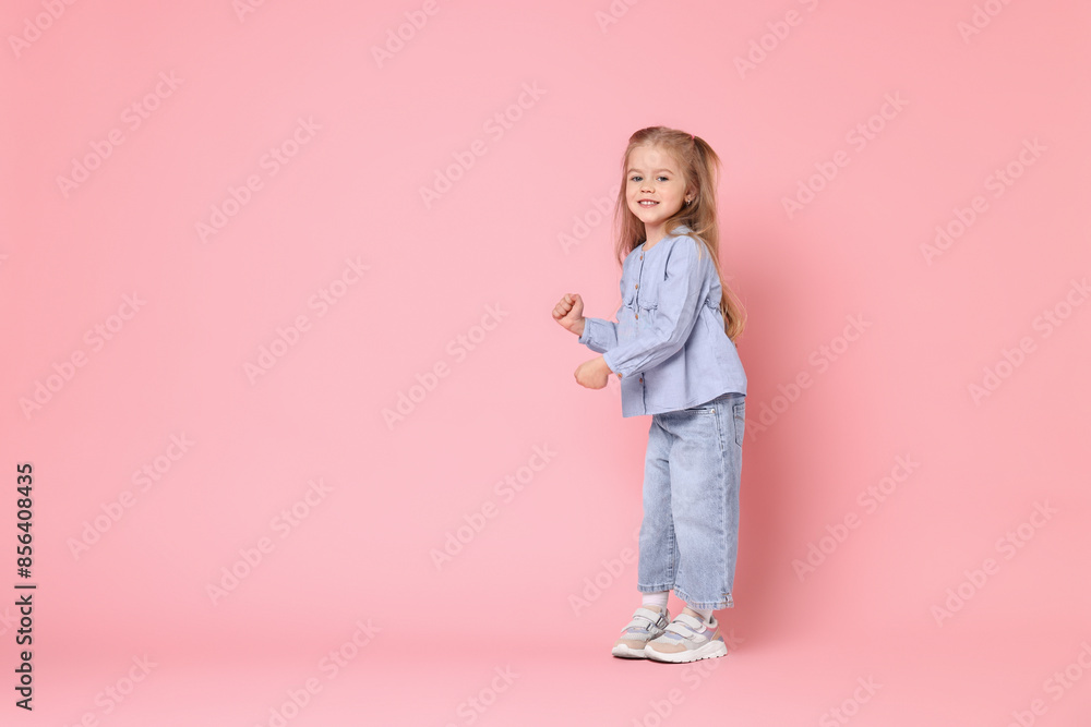 Cute little girl dancing on pink background, space for text Cute little girl dancing on pink background, space for text