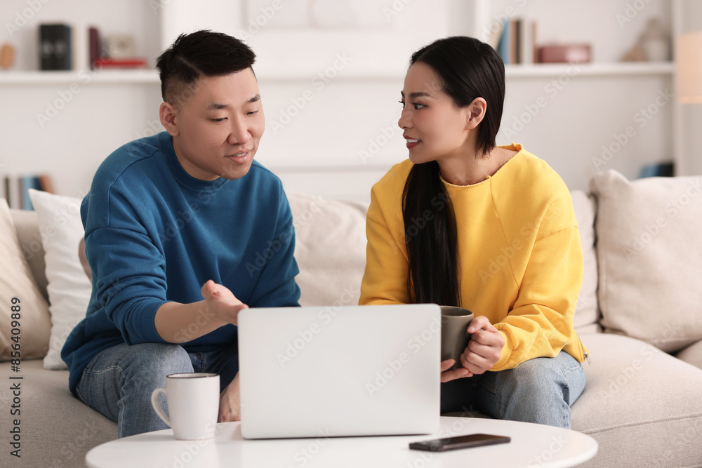 Happy couple spending time together and using laptop at home Happy couple spending time together and using laptop at home