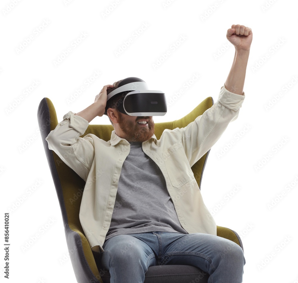 Smiling man using virtual reality headset while sitting in armchair on white background Smiling man using virtual reality headset while sitting in armchair on white background