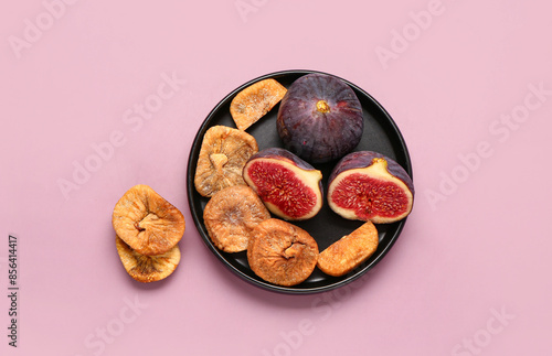 Fototapeta Naklejka Na Ścianę i Meble -  Plate with sweet dried figs and fresh fruits on purple background