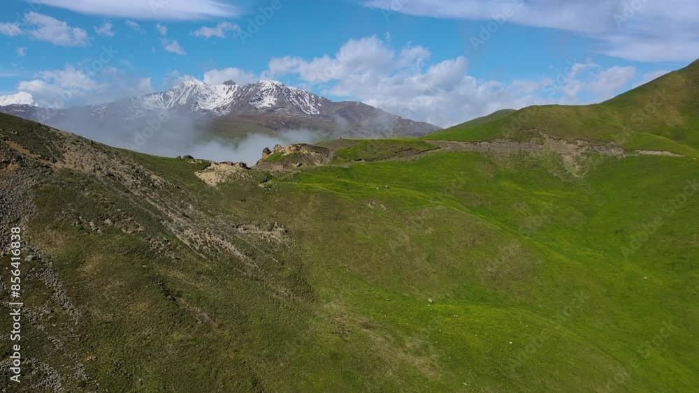 Capture the vastness of snowcapped mountains and lush green hills in a wide, breathtaking panorama Capture the vastness of snowcapped mountains and lush green hills in a wide, breathtaking panorama