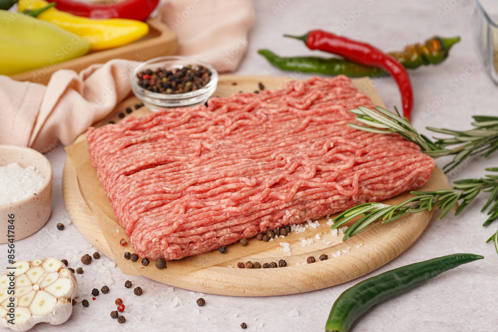 Wooden board of fresh minced meat with spices on white background Wooden board of fresh minced meat with spices on white background