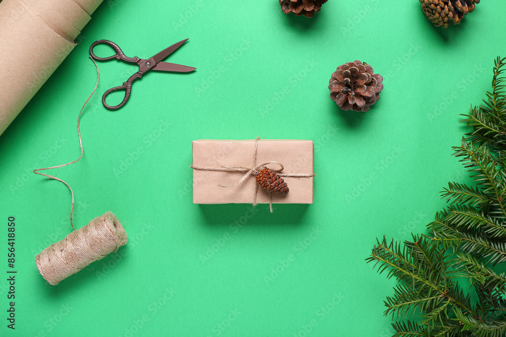 Pine cones with Christmas gift box and fir branches on green background Pine cones with Christmas gift box and fir branches on green background