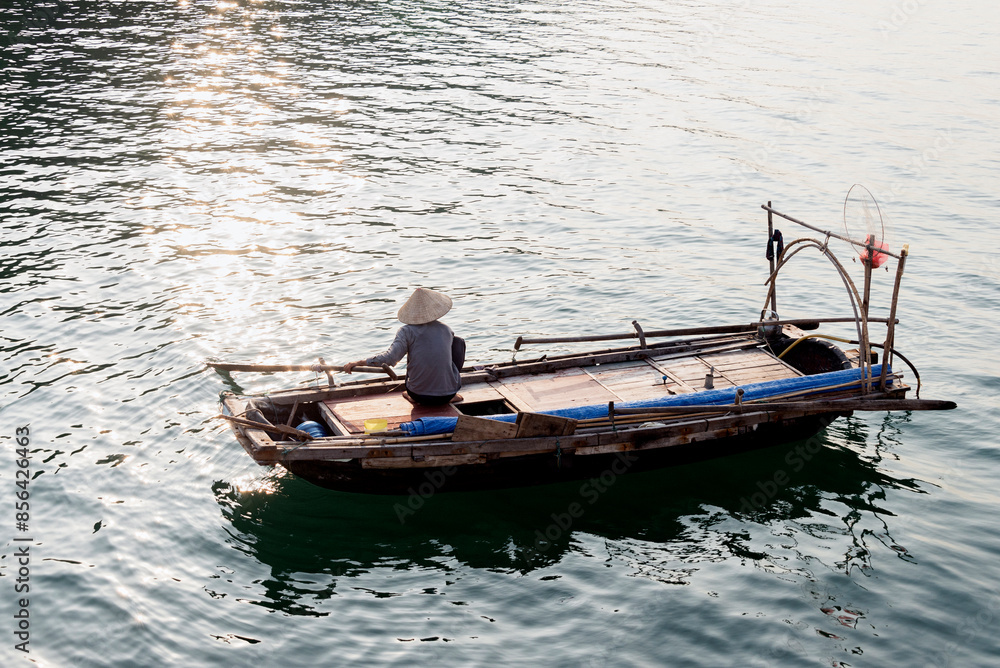 Naklejka premium Fisherman on his boat in Ha Long Bay, Vietnam