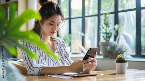 Woman using a smartphone while sitting at her desk