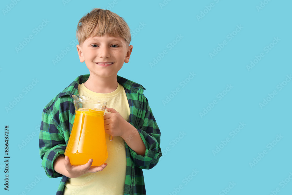 Cute little boy with carafe of lemonade on blue background Cute little boy with carafe of lemonade on blue background