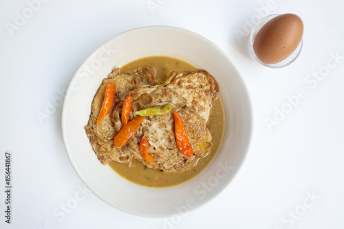 Telur ceplok masak kecap or fried eggs with sweet soy sauce. Served in white plate. Selective focus. photo