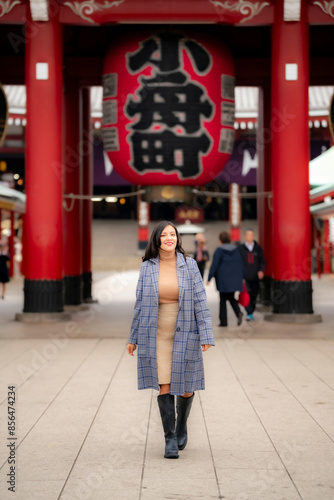 Photography A young Latina woman takes a photo at Sensoji Temple in Asakusa, Tokyo, Japan, capturing the vibrant scenery