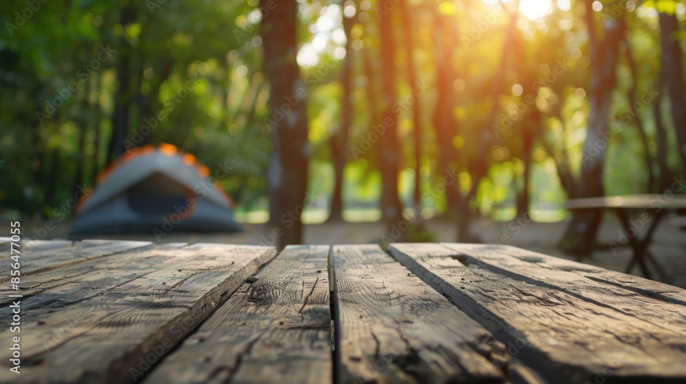 An empty wooden picnic table at a forest campsite with a tent in the background, bathed in warm sunlight. An empty wooden picnic table at a forest campsite with a tent in the background, bathed in warm sunlight.