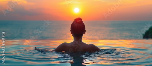 Silhouetted Woman in an Infinity Pool at Sunset