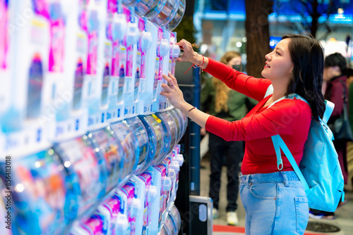 Bilde på lerret A young Latina woman smiling while playing arcade games in Akihabara, Tokyo, Japan, with glowing futuristic screens